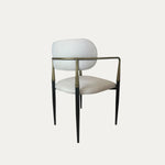 Elegance model, metal ayaklara ve yuvarlak hatlı döşemeli sırt tasarımına sahip sandalyenin arka çaprazdan görünümü.
