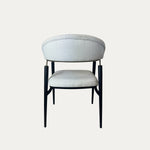 Beyaz döşemeli oturma ve sırt kısmına sahip, ince siyah metal ayaklı modern Quatro metal sandalye – arka görünüm.
