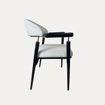 Beyaz döşemeli oturma ve sırt kısmına sahip, ince siyah metal ayaklı ve zarif kol detaylı modern Quatro metal sandalye – yan görünüm.
