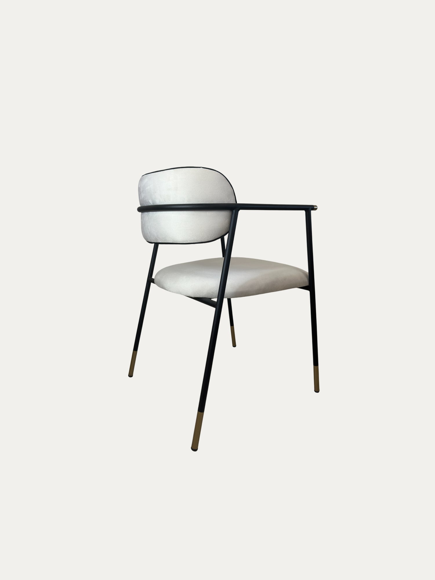 Sorel pirinç detaylı metal sandalye siyah ince metal gövde üzerine açık krem döşemeli oturum ve yuvarlak sırt tasarımıyla arka çapraz görünümde nötr arka plan üzerinde ürün fotoğrafı
