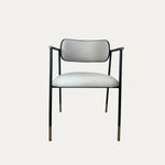 Sorel pirinç detaylı metal sandalye siyah ince metal gövde üzerine açık krem döşemeli oturum ve yuvarlak sırt tasarımıyla ön görünümde nötr arka plan üzerinde ürün fotoğrafı
