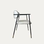 Sorel pirinç detaylı metal sandalye siyah ince metal gövde üzerine açık krem döşemeli oturum ve yuvarlak sırt tasarımıyla yan görünümde nötr arka plan üzerinde ürün fotoğrafı
